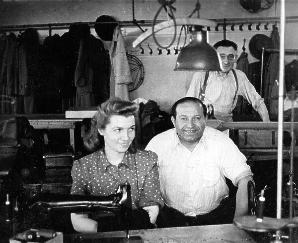 Three people in a tailors workshop