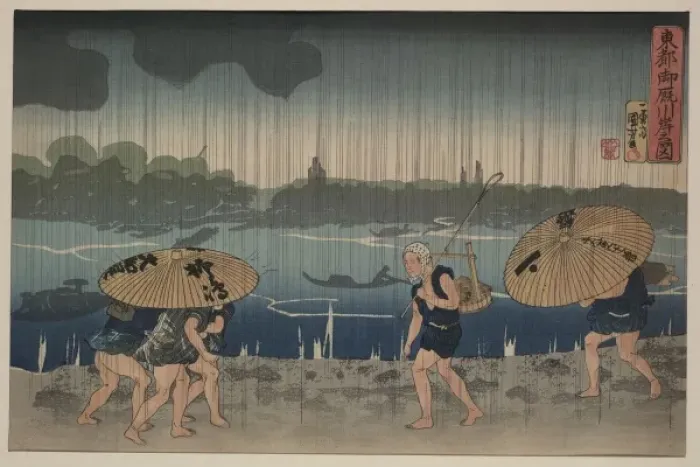 Framed Print : People walking beneath umbrellas along the seashore during a Framed Print : People walking beneath umbrellas along the seashore during a