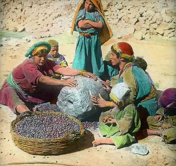 Persian women using a large grindstone, Iran