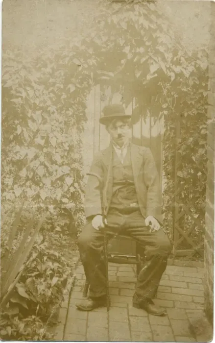 Framed Print : A person sitting in a back yard dressed up as Charlie Chaplin. Date: c. 1918 Framed Print : A person sitting in a back yard dressed up as Charlie Chaplin. Date: c. 1918