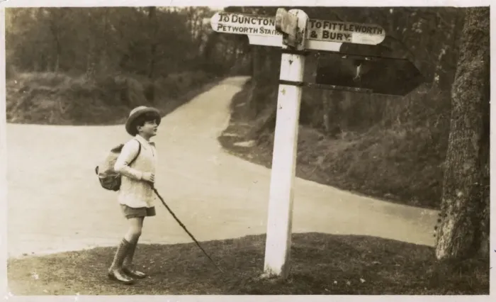 Framed Print : Petworth - Young boy checking his directions on a signpost Framed Print : Petworth - Young boy checking his directions on a signpost