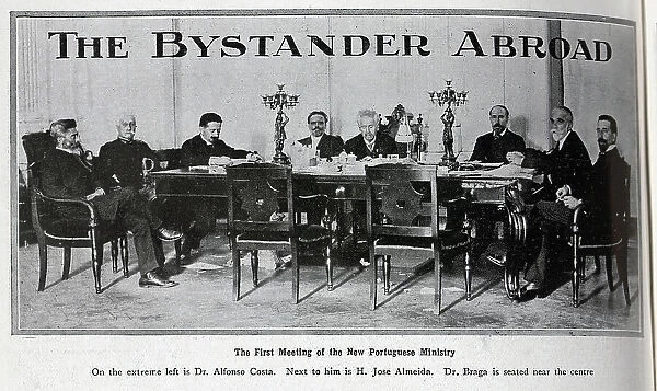 Photograph of the first meeting of the new Portuguese Ministry. With description, The First Meeting of the New Portuguese Ministry; On the extreme left is Dr Alfonso Costa. Next to him is H Jose Almeida. Dr Braga is seated near the centre