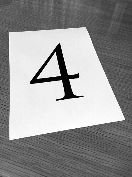 Piece of paper on a desk with a large number 4