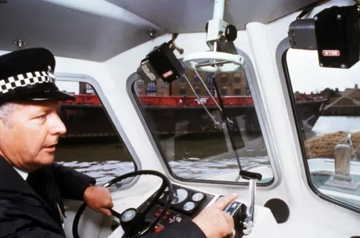Framed Print : Policeman at the controls of a riverboat Framed Print : Policeman at the controls of a riverboat