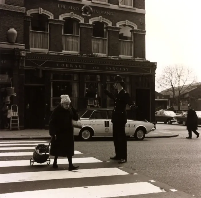 Framed Print : Policeman helping an old lady cross the road Framed Print : Policeman helping an old lady cross the road
