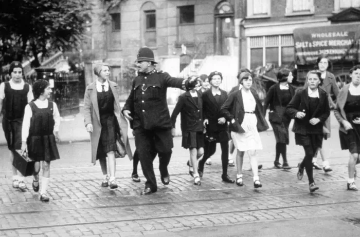 Framed Print : Policeman helping schoolgirls cross the road Framed Print : Policeman helping schoolgirls cross the road