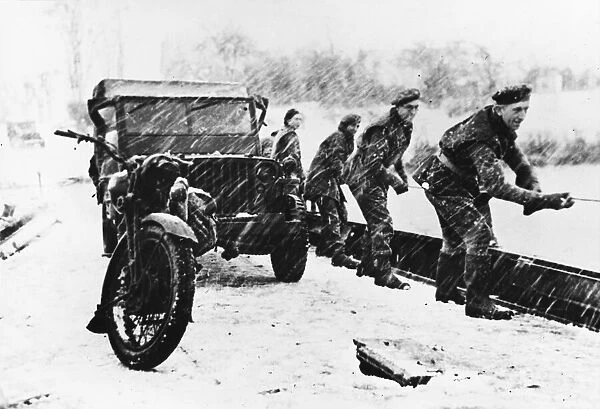 Polish soldiers crossing a river while towing a Jeep in bad weather on the Western Front