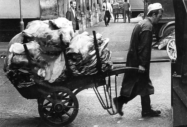 Porter pulling a loaded cart at a market