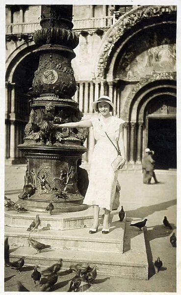 Pretty Italian Woman feeding the pigeons in front of St Marks Basilica in Venice
