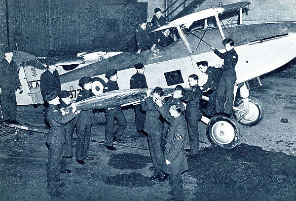 RAF cadets fitting a wing onto a fighter plane, WW2
