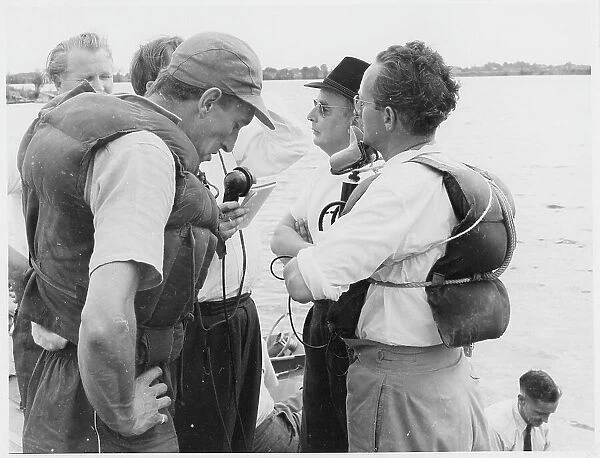 Raymond Baxter in life-jacket and base-ball cap