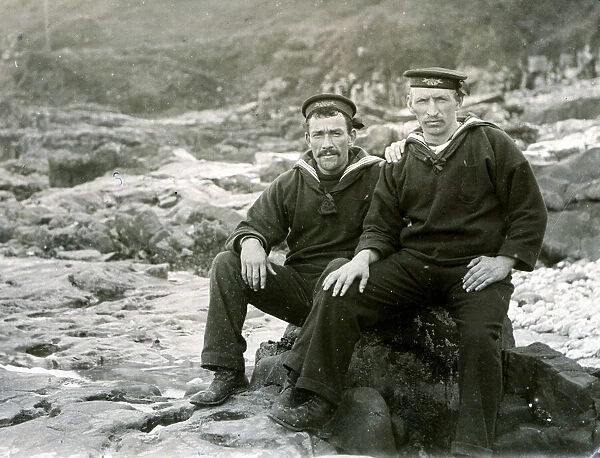Two sailors sitting on coastal rocks