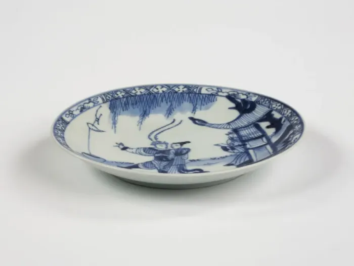 Framed Print : Saucer. Porcelain saucer with cobalt blue underglaze decoration of three figures Framed Print : Saucer. Porcelain saucer with cobalt blue underglaze decoration of three figures