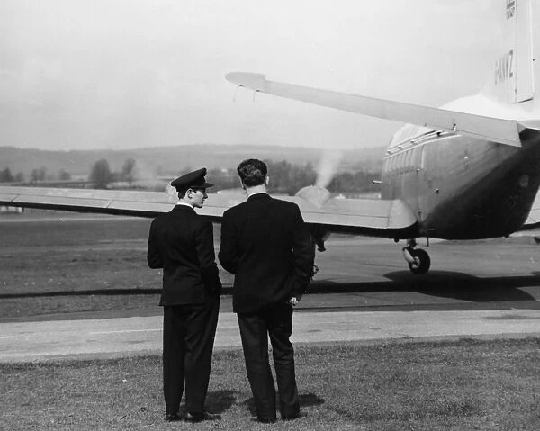 Scene at Exeter Airport, with two men and a plane