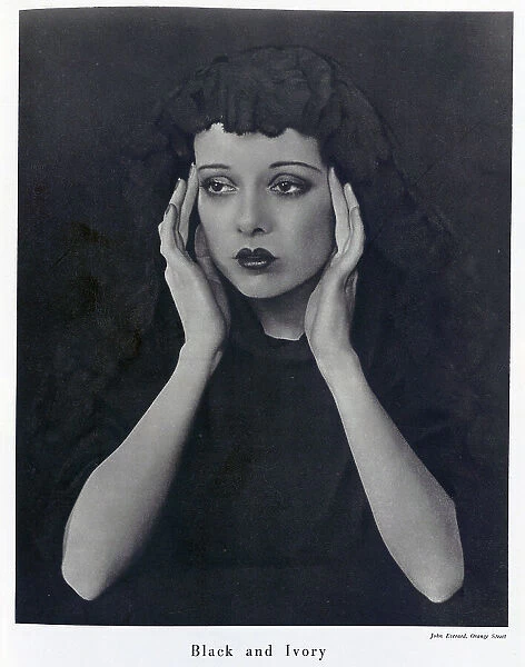 Sepha Treble, actress, (1908-1995), studio portrait wearing black mantilla. Captioned, Black and Ivory'. With description, Sepha Treble Wears a Mantilla; A black dress and a black lace mantilla, Sepha Treble's face and hands