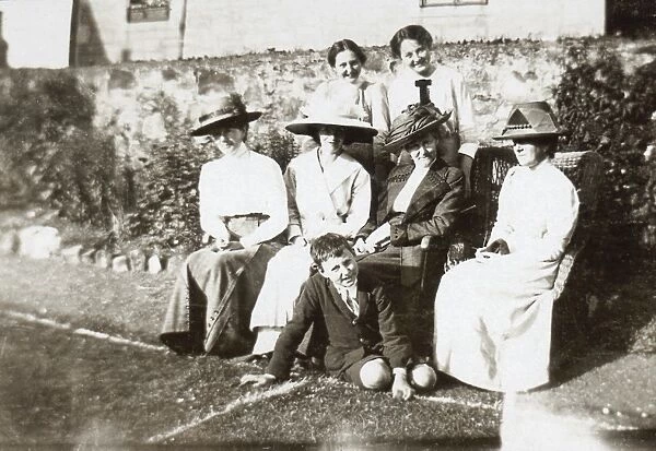Seven people at the side of a tennis court