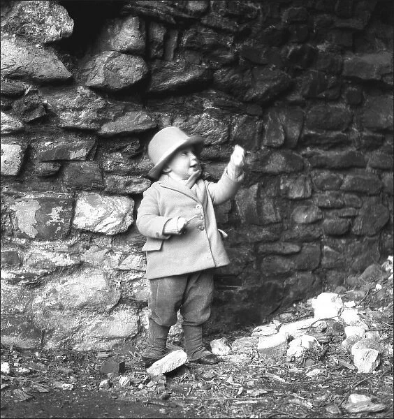 Small boy in front of a wall