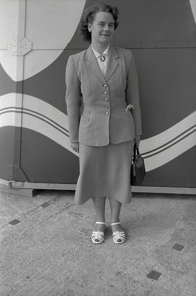 Smartly-dressed young lady in front of a patterned backdrop
