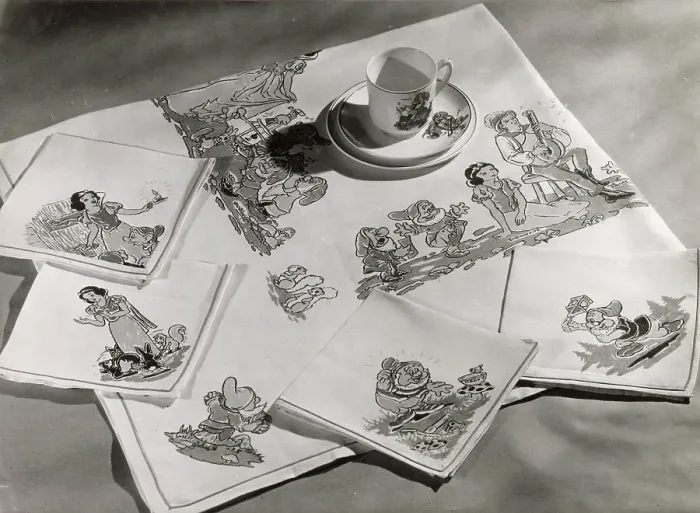 Framed Print : A Snow White and the Seven Dwarfs cup and saucer, with matching table cloth and table napkins or serviettes. Date: 1930s Framed Print : A Snow White and the Seven Dwarfs cup and saucer, with matching table cloth and table napkins or serviettes. Date: 1930s