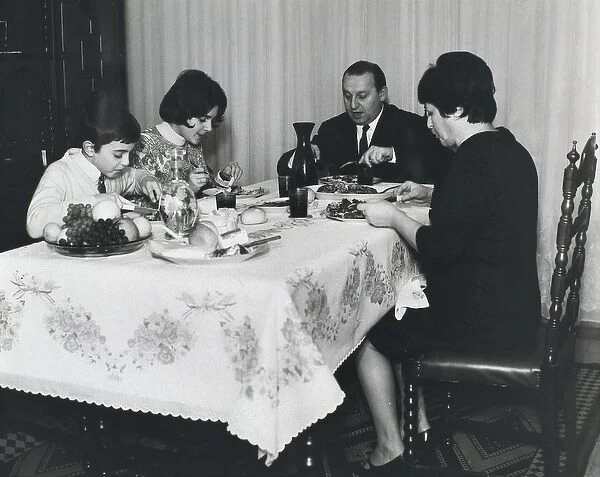 Spanish family sitting at the table at mealtime