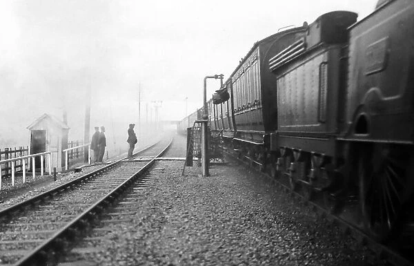 Steam train picking up mail bag, early 1900s