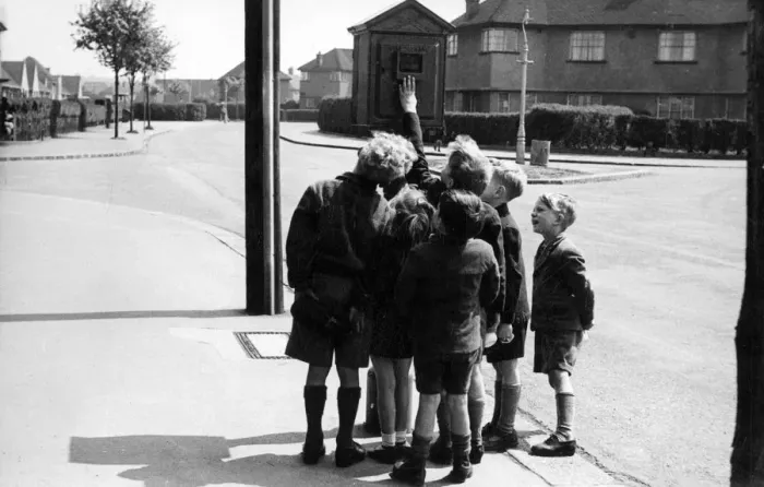 Framed Print : Street telephone fire alarm with group of children Framed Print : Street telephone fire alarm with group of children