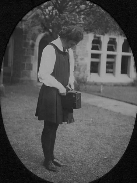 Student standing with box camera