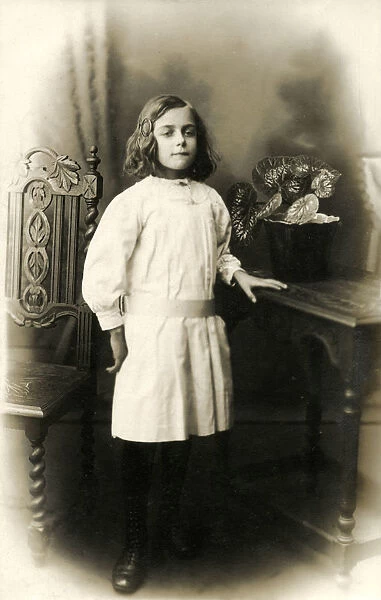 Studio photographic portrait of a young girl in white dress