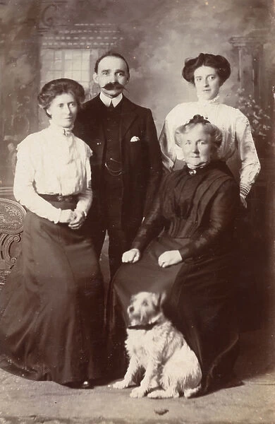 Studio portrait, family of four with terrier dog