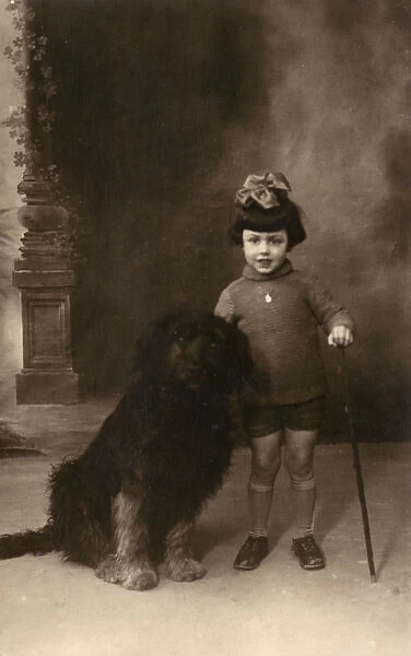 Studio portrait, little girl with large dog, France