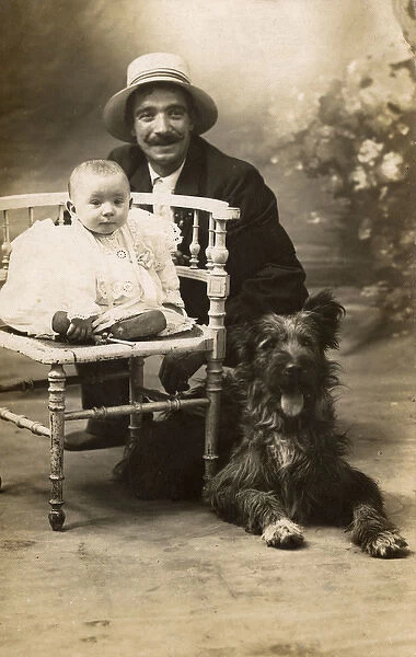 Studio portrait, man with baby and dog, France