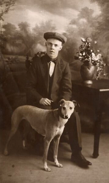 Studio portrait, young man with lurcher