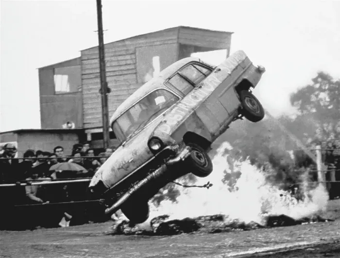 Framed Print : A stunt car flies through the air over a bonfire of tyres, watched by spectators standing in the rain. Date: 1960s Framed Print : A stunt car flies through the air over a bonfire of tyres, watched by spectators standing in the rain. Date: 1960s