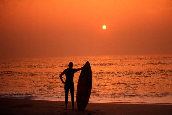 Surfer standing admiring a Cornish Sunset