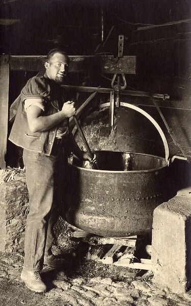 Swiss Cheesemaker stiring a large vat