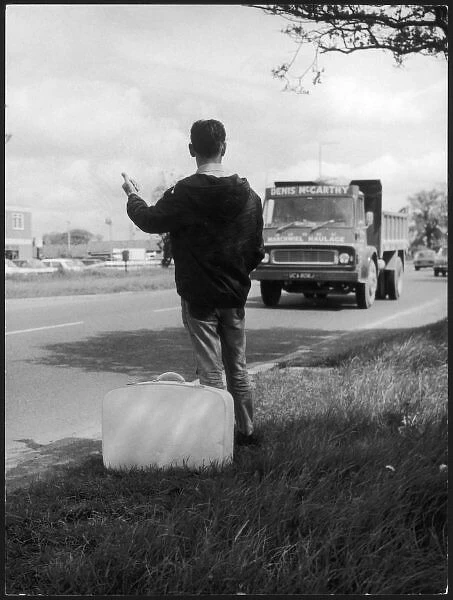 Thumbing a Lift. A young man hitch hiker, thumbs a lift from a Denis McCarthy lorry