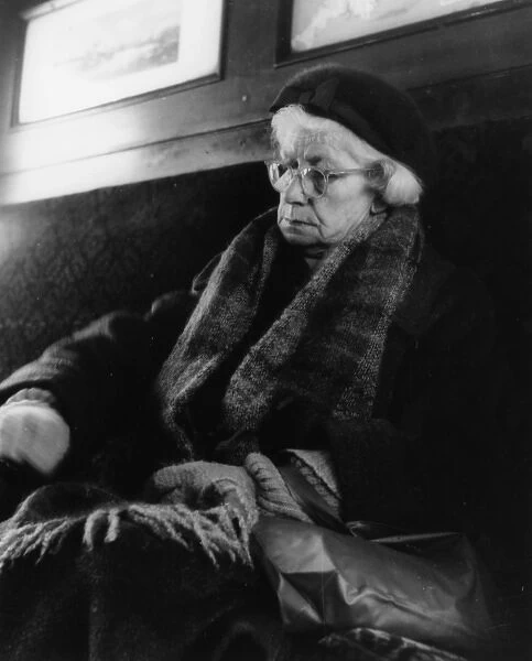 Tired elderly woman sleeping on a train