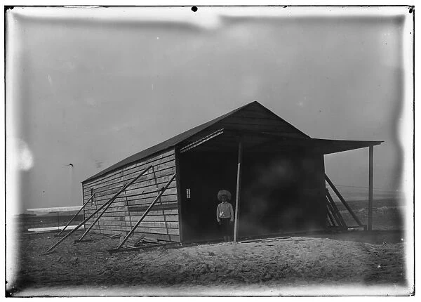 Tom Tate in front of camp building at Kitty Hawk, North Caro