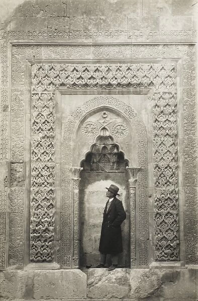 A tourist before an elaborate Turkish carved alcove