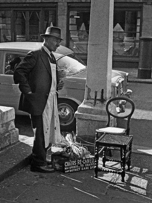 Framed Print : Tradesman repairs chairs in Central London street Framed Print : Tradesman repairs chairs in Central London street