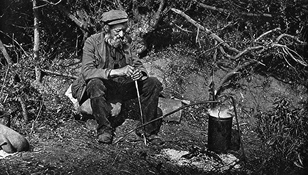 A tramp sitting next to a fire