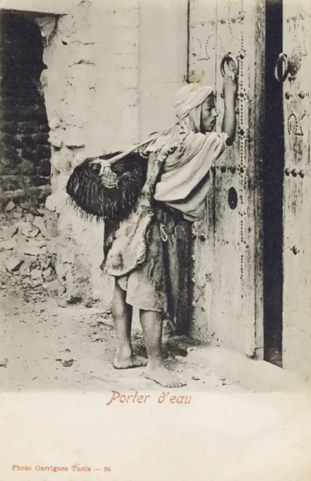 Framed Print : Tunisia, Water Carrier knocking at an impressive wooden door Framed Print : Tunisia, Water Carrier knocking at an impressive wooden door