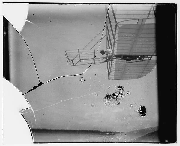 Side view of Wilbur Wright piloting a glider in level flight