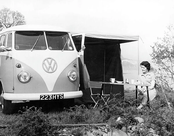 VW Camper Van. A woman demonstrates how convenient it is to have ones breakfast