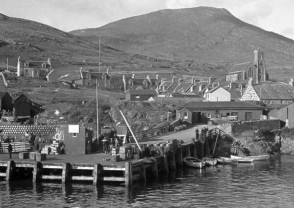 Waterside scene with jetty, houses and church, Scotland