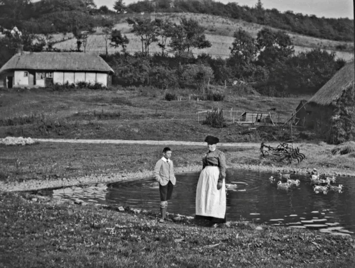 Framed Print : Woman and boy standing by a duckpond Framed Print : Woman and boy standing by a duckpond