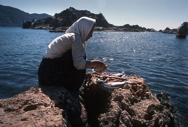 Woman cleaning fish, Turkey
