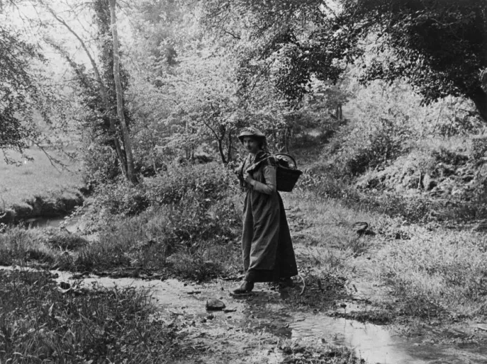 Framed Print : Woman crossing a brook, 1890s Framed Print : Woman crossing a brook, 1890s