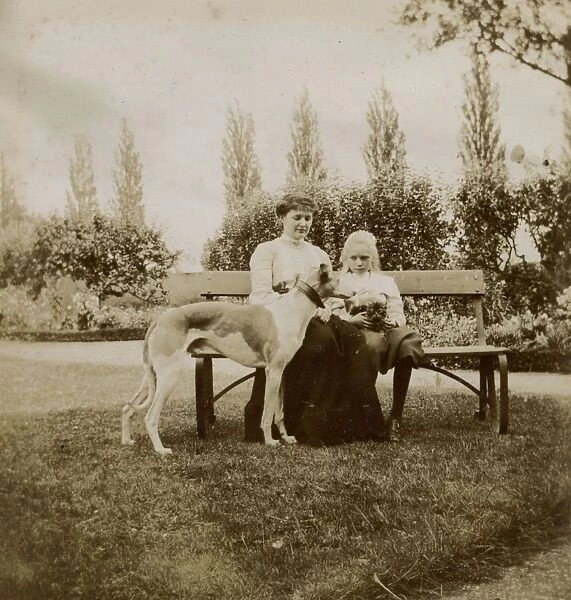 Woman and girl with dog and cat on a garden bench