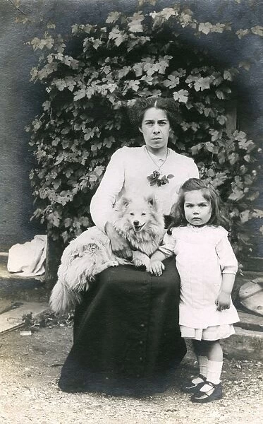 Woman and girl with dog in a garden